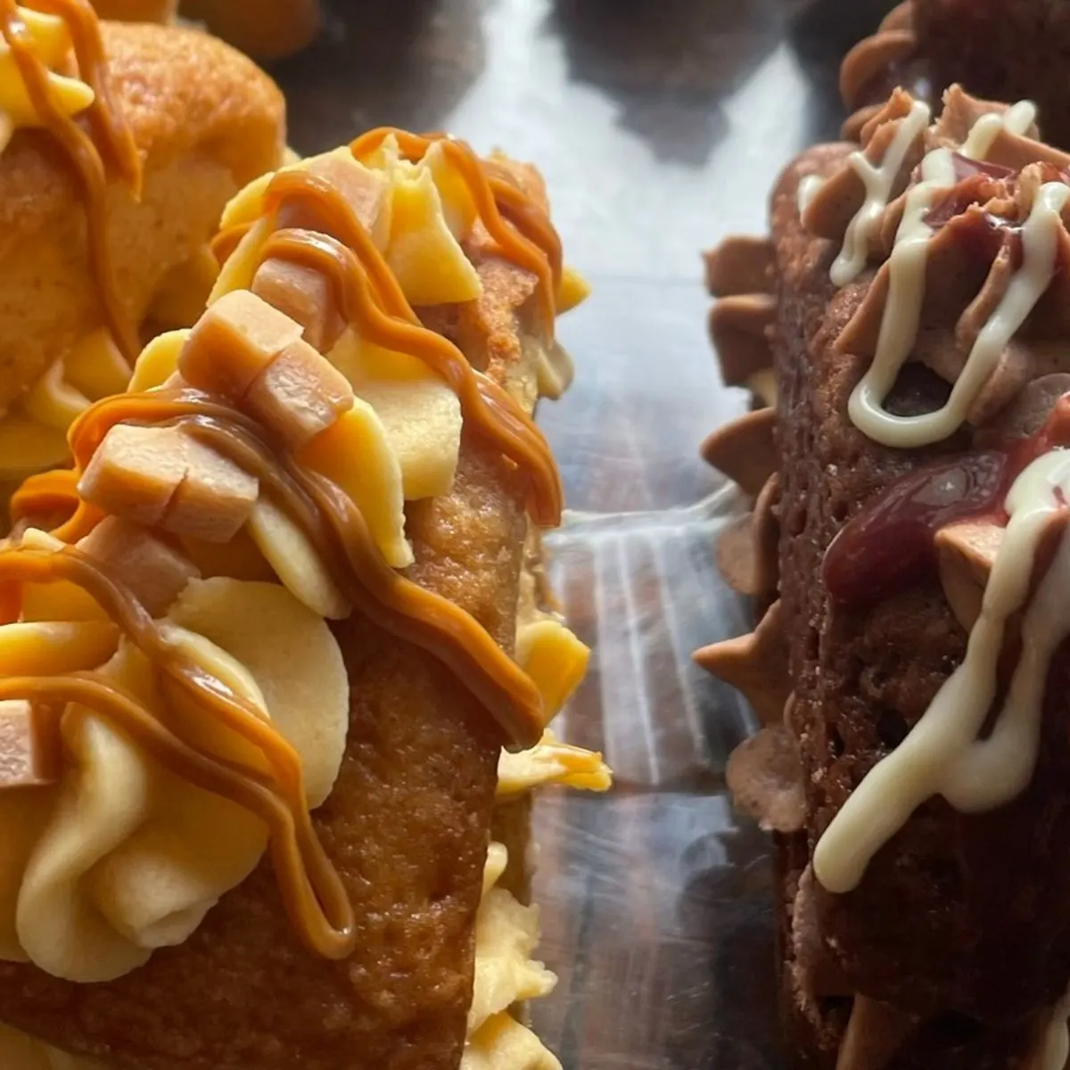 Close-up of caramel bakes piped with buttercream and drizzled with caramel sauce